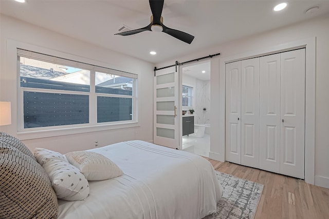 4434 Sarong Dr, Houston, TX 77096 - bedroom featuring a barn door, light wood finished floors, recessed lighting, ensuite bathroom, and a closet