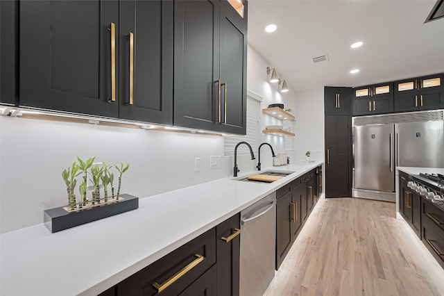 4434 Sarong Dr, Houston, TX 77096 - kitchen featuring a sink, stainless steel appliances, light wood-type flooring, light countertops, and glass insert cabinets