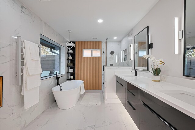 4434 Sarong Dr, Houston, TX 77096 - bathroom featuring a marble finish shower, double vanity, a freestanding bath, marble finish flooring, and recessed lighting