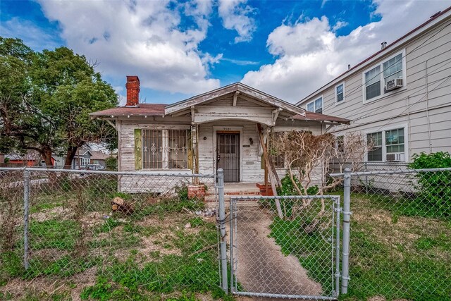 3301 Holman St, Houston, TX 77004 - view of front facade with a gate, a chimney, a fenced front yard, covered porch, and cooling unit