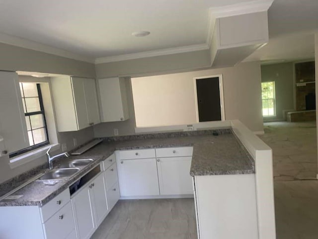 167 County Road 3665 W, Splendora, TX 77372 - kitchen featuring light marble finish floors, a sink, crown molding, white cabinets, and a peninsula