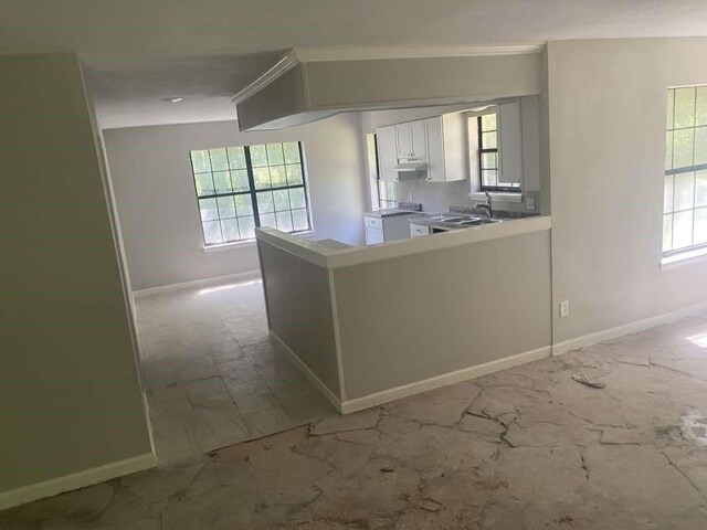 167 County Road 3665 W, Splendora, TX 77372 - kitchen with a peninsula, baseboards, ornamental molding, white cabinets, and light countertops