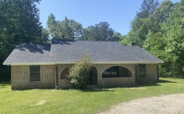 167 County Road 3665 W, Splendora, TX 77372 - view of front of house featuring a front lawn, a shingled roof, and brick siding