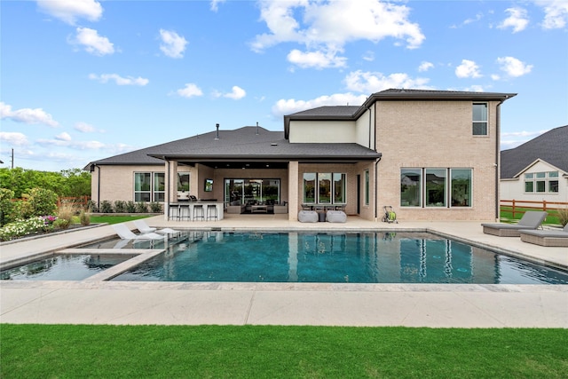 7851 Longhorn Trl, Fulshear, TX 77406 - back of house with a patio, brick siding, and a pool with connected hot tub