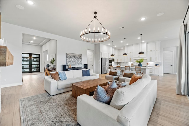 7851 Longhorn Trl, Fulshear, TX 77406 - living room with light wood-style flooring, a chandelier, recessed lighting, and baseboards