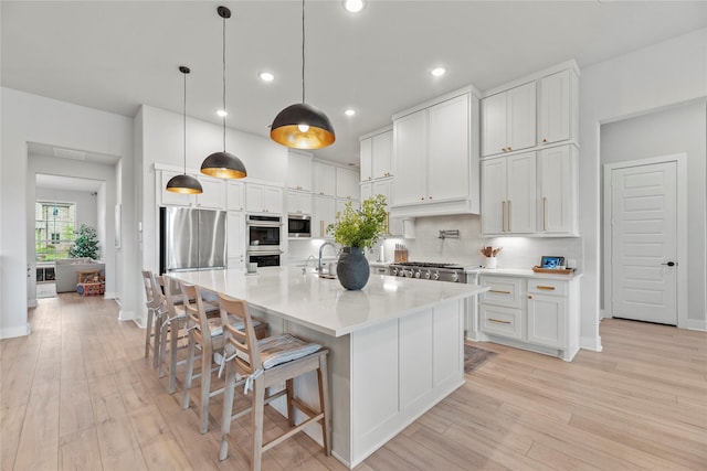 7851 Longhorn Trl, Fulshear, TX 77406 - kitchen with appliances with stainless steel finishes, backsplash, light wood-style flooring, white cabinets, and recessed lighting