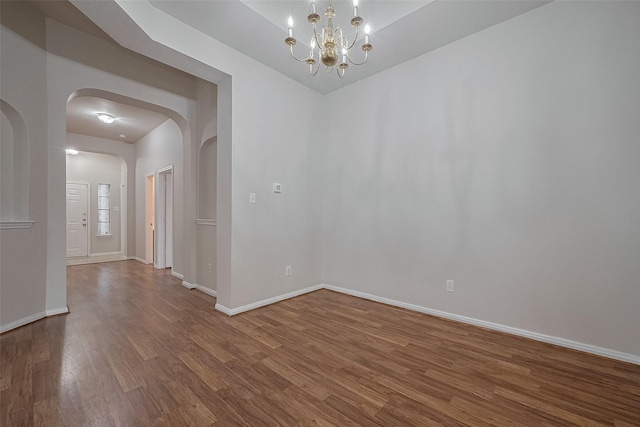 7407 Breda Dr, Baytown, TX 77521 - unfurnished room with arched walkways, wood finished floors, a chandelier, and baseboards