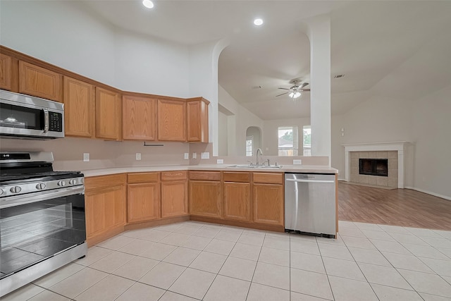 7407 Breda Dr, Baytown, TX 77521 - kitchen with appliances with stainless steel finishes, vaulted ceiling, a sink, ceiling fan, and light countertops