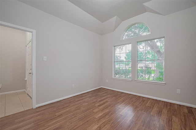 7407 Breda Dr, Baytown, TX 77521 - spare room with healthy amount of natural light, wood finished floors, lofted ceiling, and baseboards