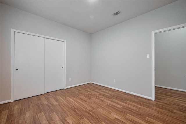 7407 Breda Dr, Baytown, TX 77521 - unfurnished bedroom featuring wood finished floors, baseboards, and a closet