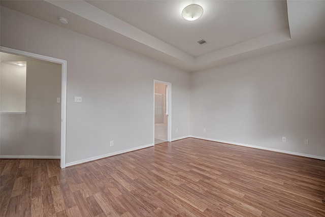 7407 Breda Dr, Baytown, TX 77521 - unfurnished room featuring a tray ceiling, wood finished floors, a smoke detector, and baseboards