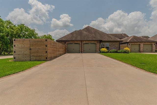 7705 Savannah, Beaumont, TX 77707 - view of front of property with an attached garage, concrete driveway, and brick siding