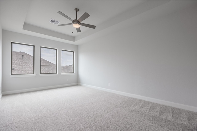 813 Laguna Green Ln, Katy, TX 77493 - empty room with a raised ceiling, light carpet, and a ceiling fan