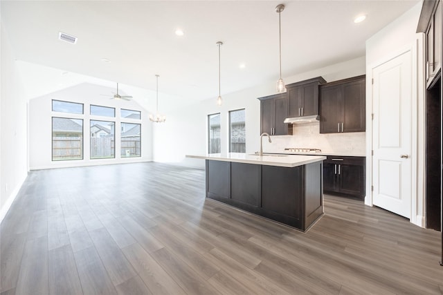 813 Laguna Green Ln, Katy, TX 77493 - kitchen featuring open floor plan, wood finished floors, a chandelier, under cabinet range hood, and recessed lighting