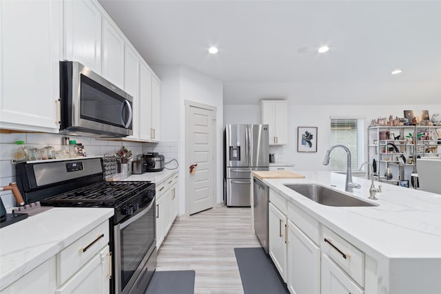7011 Fleetwood Crescent Way, Richmond, TX 77407 - kitchen featuring stainless steel appliances, a sink, white cabinets, and recessed lighting