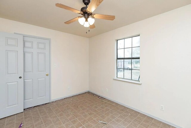 408 S Live Oak St, Mathis, TX 78368 - unfurnished bedroom with light flooring, baseboards, and a ceiling fan