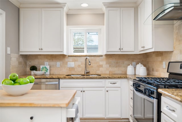1007 W 43rd St, Houston, TX 77018 - kitchen with stainless steel appliances, a sink, butcher block counters, wall chimney exhaust hood, and crown molding