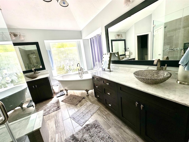 8910 Everhart Ln, Houston, TX 77040 - bathroom with lofted ceiling, two vanities, a stall shower, a freestanding bath, and wood finish floors