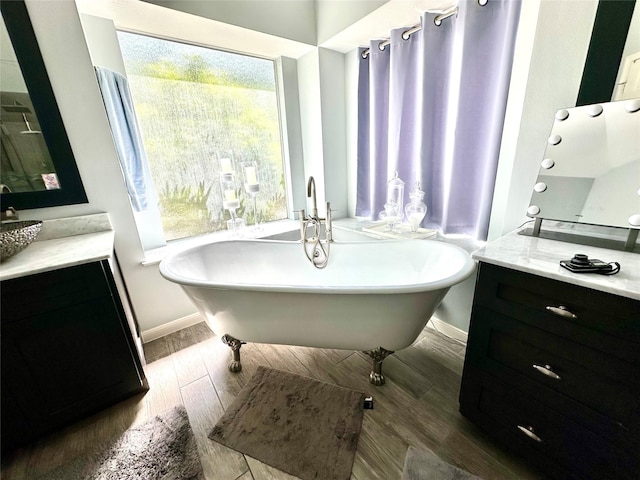 8910 Everhart Ln, Houston, TX 77040 - bathroom with wood finished floors, baseboards, a freestanding tub, and vanity