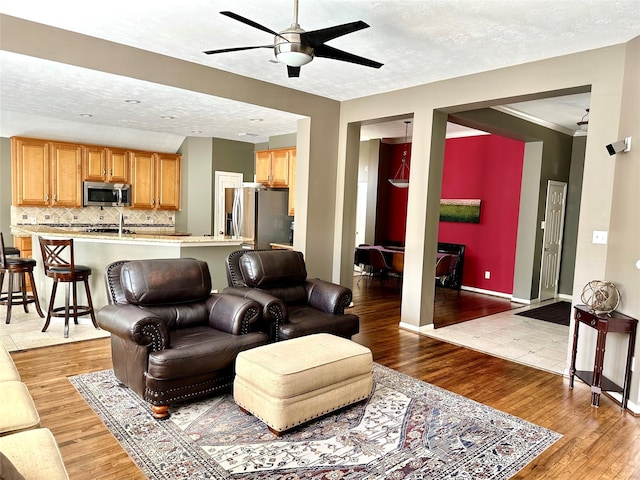 8910 Everhart Ln, Houston, TX 77040 - living area with ceiling fan, light wood-style flooring, a textured ceiling, and baseboards
