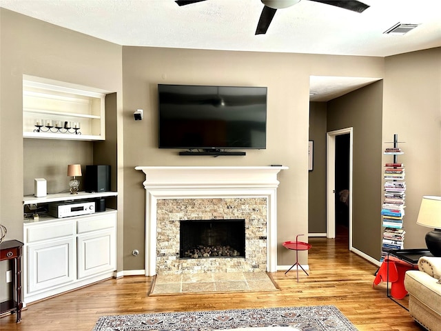 8910 Everhart Ln, Houston, TX 77040 - living area with wood finished floors, ceiling fan, a stone fireplace, and baseboards