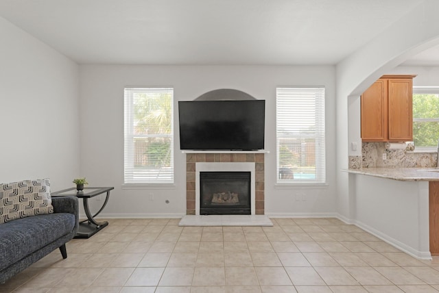 6426 Savannah Pines Dr, Katy, TX 77449 - living room with a tile fireplace, light tile patterned flooring, and baseboards