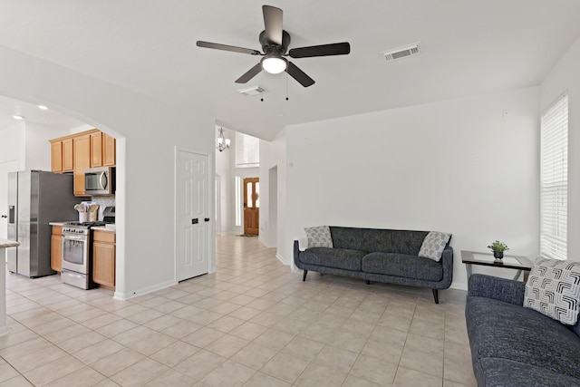 6426 Savannah Pines Dr, Katy, TX 77449 - living area with ceiling fan, baseboards, light tile patterned flooring, and arched walkways