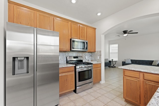 6426 Savannah Pines Dr, Katy, TX 77449 - kitchen featuring stainless steel appliances, backsplash, light tile patterned flooring, a ceiling fan, and open floor plan