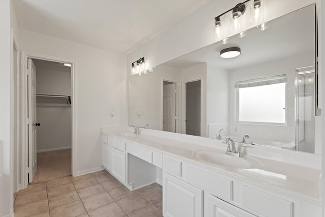 6426 Savannah Pines Dr, Katy, TX 77449 - bathroom featuring double vanity, a walk in closet, a stall shower, tile patterned flooring, and a garden tub