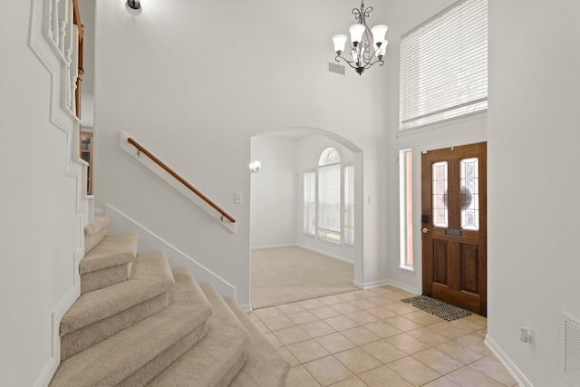6426 Savannah Pines Dr, Katy, TX 77449 - entrance foyer with a towering ceiling, arched walkways, stairs, light tile patterned flooring, and a chandelier