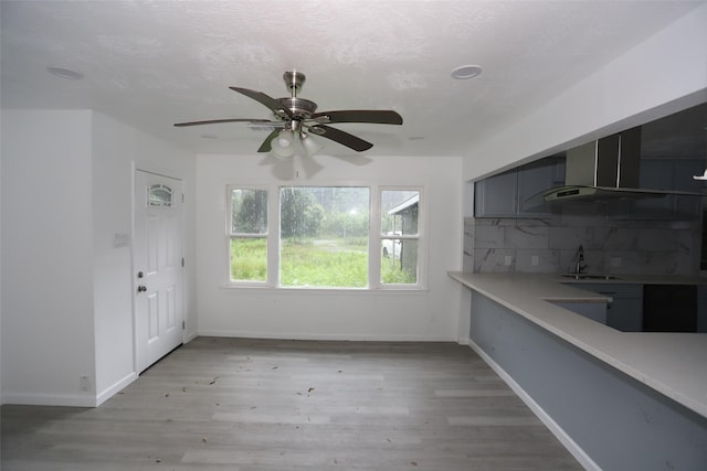345 Byrd St, Vidor, TX 77662 - unfurnished dining area with a sink, a ceiling fan, light wood-style floors, and baseboards