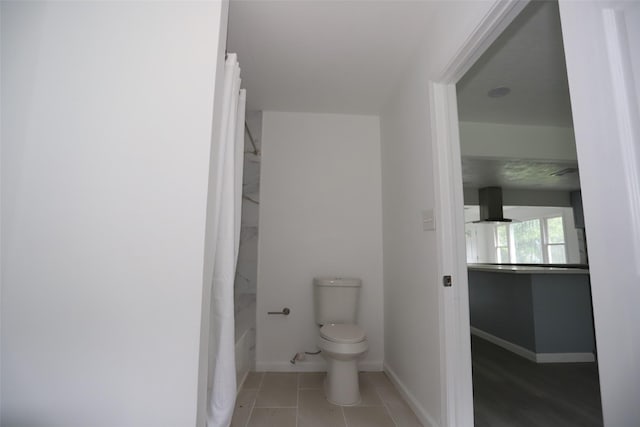 345 Byrd St, Vidor, TX 77662 - bathroom with toilet, baseboards, tile patterned floors, and shower / bath combination with curtain