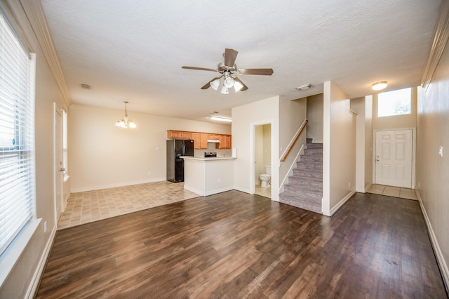 12510 Panther Place Dr, Houston, TX 77099 - unfurnished living room with wood finished floors, a chandelier, stairway, a ceiling fan, and baseboards