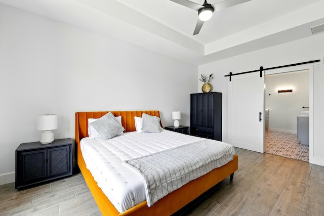 16522 N Canyon Trace Dr, Houston, TX 77095 - bedroom featuring a barn door, wood finished floors, ceiling fan, and baseboards