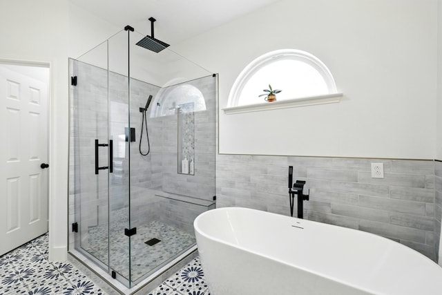16522 N Canyon Trace Dr, Houston, TX 77095 - full bathroom featuring a freestanding tub, a stall shower, tile patterned flooring, and tile walls