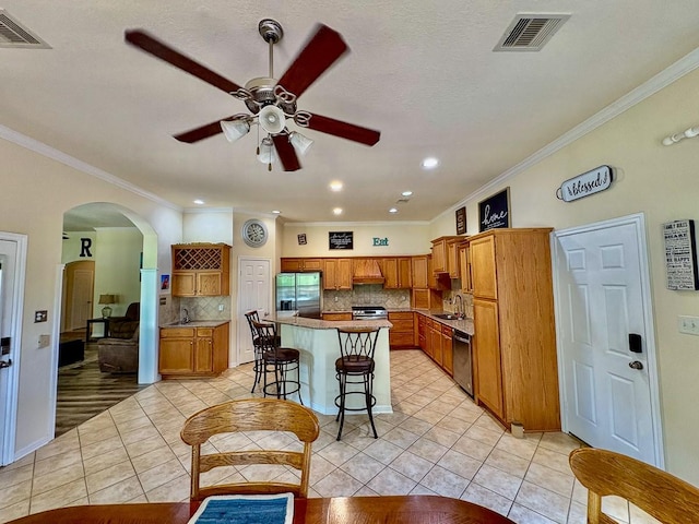 18 Joe Werner Ln, Huntsville, TX 77320 - kitchen featuring stainless steel appliances, a sink, a ceiling fan, crown molding, and arched walkways