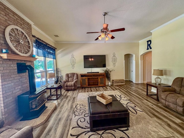 18 Joe Werner Ln, Huntsville, TX 77320 - living area featuring a ceiling fan, wood finished floors, crown molding, arched walkways, and a wood stove
