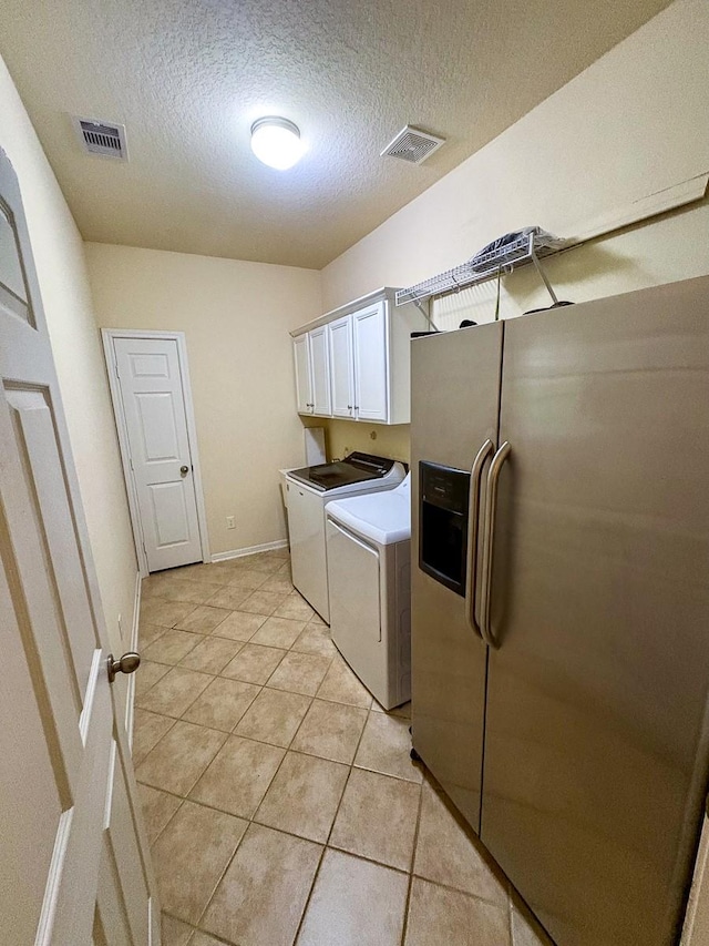 18 Joe Werner Ln, Huntsville, TX 77320 - laundry room featuring washer and clothes dryer, a textured ceiling, cabinet space, light tile patterned flooring, and baseboards