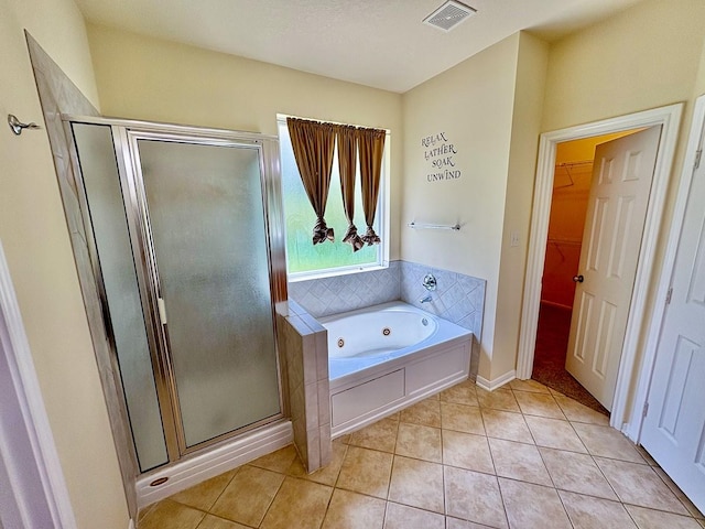 18 Joe Werner Ln, Huntsville, TX 77320 - full bath featuring a shower stall, a tub with jets, tile patterned floors, and a spacious closet