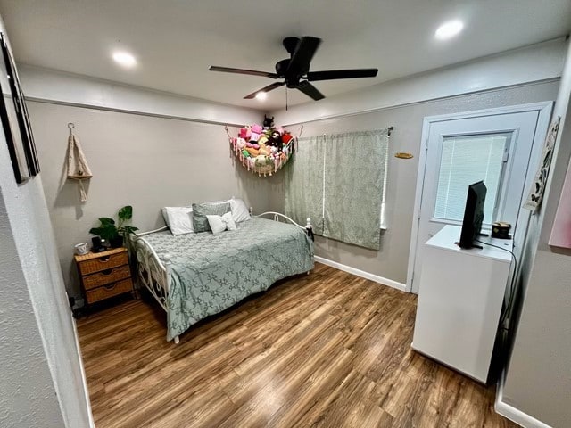 1409 20th St, Huntsville, TX 77340 - bedroom featuring wood finished floors, ceiling fan, and baseboards