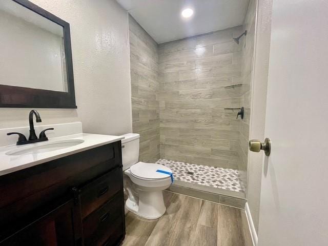 1409 20th St, Huntsville, TX 77340 - bathroom with vanity, a tile shower, toilet, and wood finished floors
