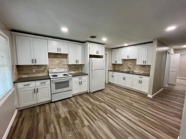 1409 20th St, Huntsville, TX 77340 - kitchen with white appliances, dark countertops, dark wood-style flooring, baseboards, and decorative backsplash