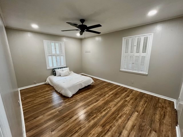 1409 20th St, Huntsville, TX 77340 - bedroom with wood finished floors, ceiling fan, recessed lighting, and baseboards