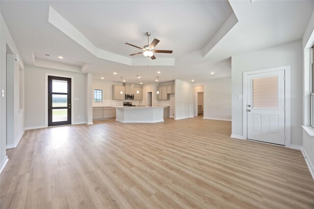 540 Barton Place Dr, Cleveland, TX 77327 - unfurnished living room with a raised ceiling, a ceiling fan, light wood-style floors, baseboards, and recessed lighting
