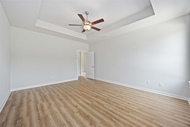 540 Barton Place Dr, Cleveland, TX 77327 - unfurnished room featuring a tray ceiling, light wood-style flooring, baseboards, and a ceiling fan