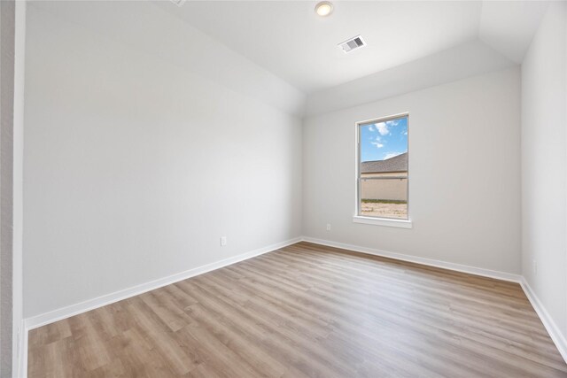 540 Barton Place Dr, Cleveland, TX 77327 - spare room with light wood-type flooring, lofted ceiling, and baseboards
