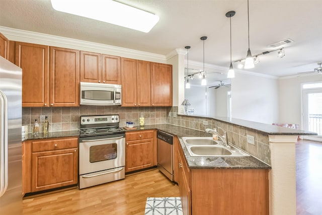 1711 Old Spanish Trl Unit 406, Houston, TX 77054 - kitchen featuring stainless steel appliances, a sink, a ceiling fan, ornamental molding, and a peninsula