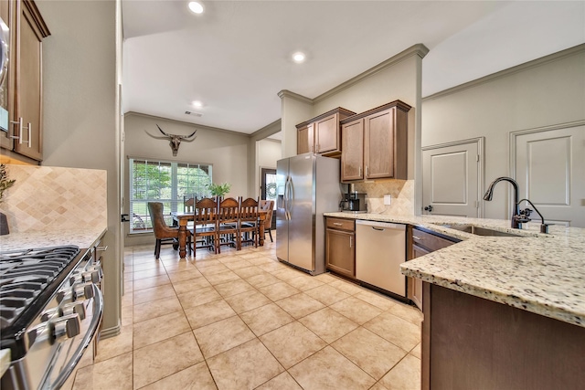 1586 Ancient Oak Ln, Conroe, TX 77301 - kitchen with appliances with stainless steel finishes, ornamental molding, backsplash, recessed lighting, and light tile patterned flooring