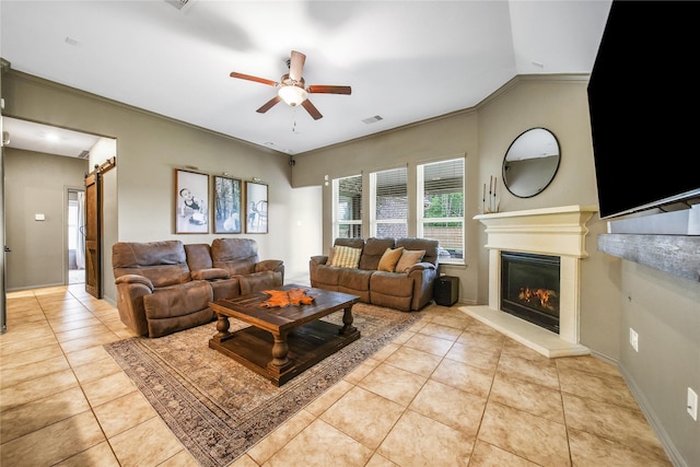 1586 Ancient Oak Ln, Conroe, TX 77301 - living room with light tile patterned flooring, ceiling fan, a glass covered fireplace, a barn door, and crown molding