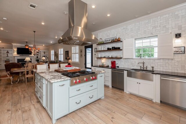 5950 Keith Rd, Lumberton, TX 77657 - kitchen featuring stainless steel appliances, island range hood, open floor plan, a sink, and ornamental molding